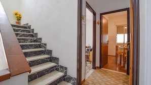 A staircase with marble steps leading to a room with a patterned floor and a wooden door. - Cozy apartment in Chianchitta - Pallio with WiFi (Chianchitta - Pallio)