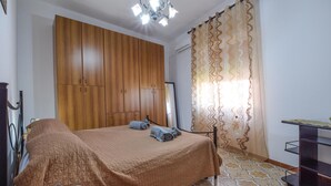 A bedroom with a bed, wooden wardrobe, and a mirror. - Cozy apartment in Chianchitta - Pallio with WiFi (Chianchitta - Pallio)