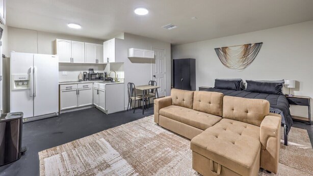 Un appartement moderne comprenant un coin cuisine, un canapé, un lit et un espace repas.