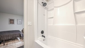 Une salle de bain moderne avec une baignoire et une douche blanches.
