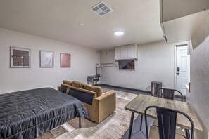 Une pièce de taille modeste comprenant un lit, un canapé, une petite table et un coin cuisine.
