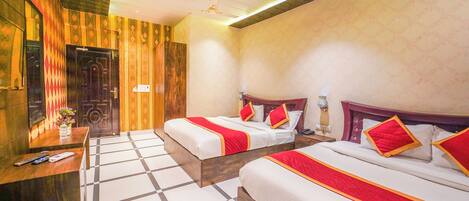 A hotel room with two beds, a wooden reception desk, and a check-in counter.