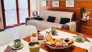 A hotel room with a dining area, a sofa, and a bed. There are pictures on the wall and a basket of food on the table. - Mattia House within walking distance of the Center  (Lucca)