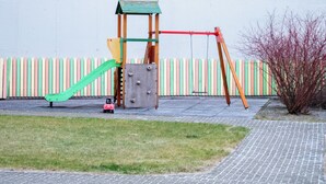 A playground with a slide, climbing structure, and swings.