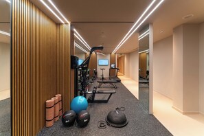 Un gimnasio moderno con equipamiento de ejercicio, cintas de correr y pesas.
