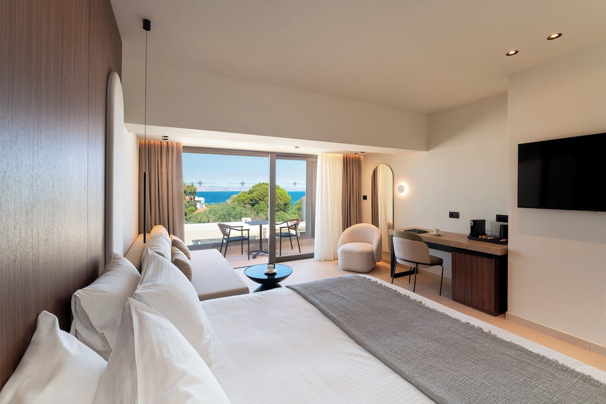 Deluxe Triple Room Sea View | Een minibar, een kluis op de kamer, een bureau, een laptopwerkplek