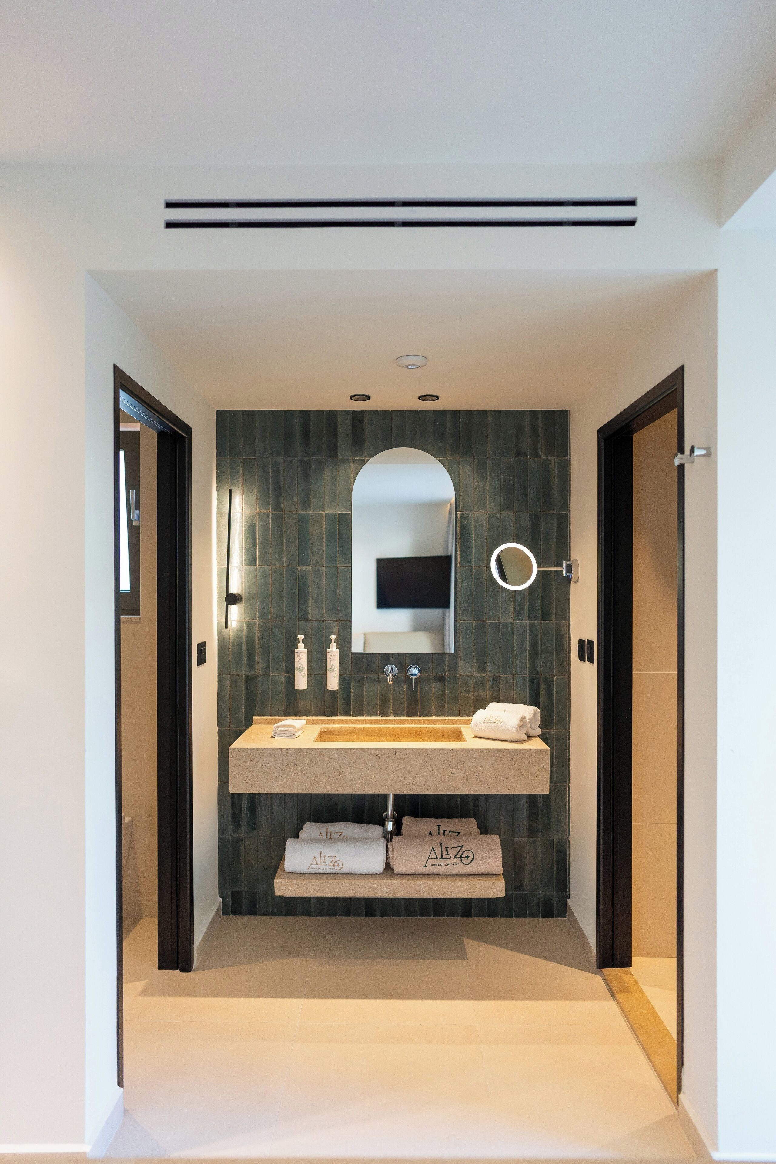 Un baño moderno con un espejo grande, un lavabo y un perchero para toallas.