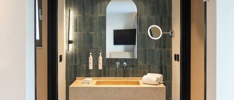 Un baño moderno con un espejo grande, un lavabo y un perchero para toallas.