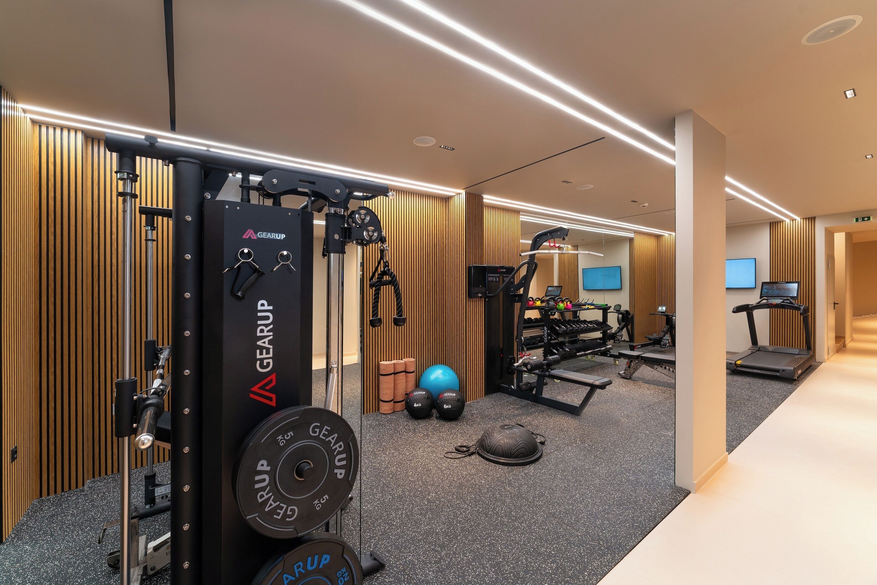 Ein modernes Fitnessstudio mit Gewichthebezeugen, Laufbändern und Trainingsbällen.