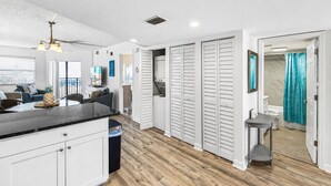 Une cuisine moderne dotée d’un îlot central, de meubles blancs et d’un plancher en bois.