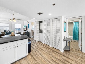 Une cuisine moderne dotée d’un îlot central, de meubles blancs et d’un plancher en bois.