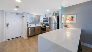 Een moderne keuken met roestvrijstalen apparatuur, houten kastjes en een wit aanrecht.