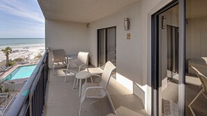 Un balcon avec une piscine, des chaises et une vue sur la plage.