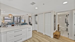 Een moderne keuken met witte kasten, een houten aanrecht en een hanglamp.