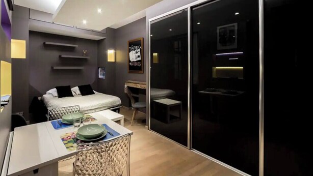 A modern bedroom with a bed, desk, and sliding glass door leading to a dark room. - La Cachette St Jean: Calm and serenity in Vieux Lyon (Lyon)