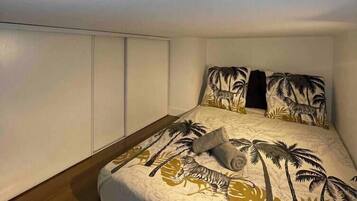 Een slaapkamer met een bed, twee kussens en een deken.