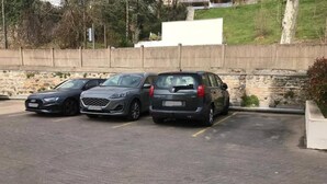A parking lot with three cars parked in a row. - To complete (Lyon)