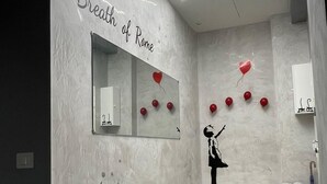 A modern interior with a marble wall, a mirror, and a red counter.
