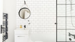 A bathroom with a white sink, mirror, and a shower with a glass door.