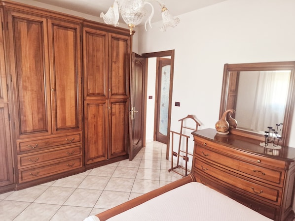 A bedroom with a large wardrobe, a dresser, a bed, and a mirror. - Cà Elena house located in the Po Delta park a few kilometers from Lido di Volano  (Emilia-Romagna)