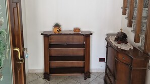 A hallway with a wooden bench, a small table with decorative items, and a staircase. - Cà Elena house located in the Po Delta park a few kilometers from Lido di Volano  (Emilia-Romagna)