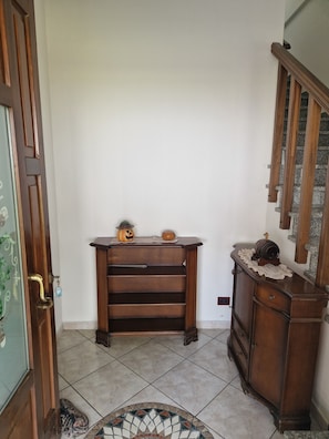 A hallway with a wooden bench, a small table with decorative items, and a staircase. - Cà Elena house located in the Po Delta park a few kilometers from Lido di Volano  (Emilia-Romagna)