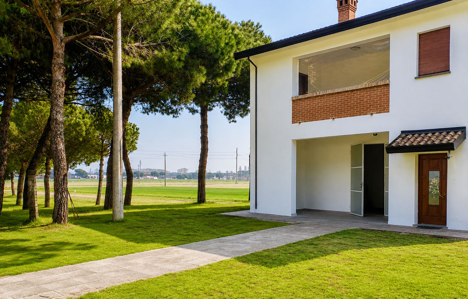 A modern two-story house with a paved driveway and a grassy lawn.