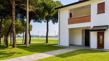A modern two-story house with a paved driveway and a grassy lawn.