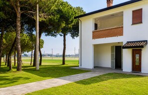 Ein modernes, zweistöckiges Haus mit gepflasterter Auffahrt und Rasenfläche.