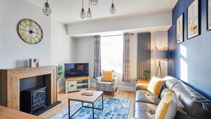 Un salon moderne avec une cheminée, un canapé en cuir et une grande horloge murale.