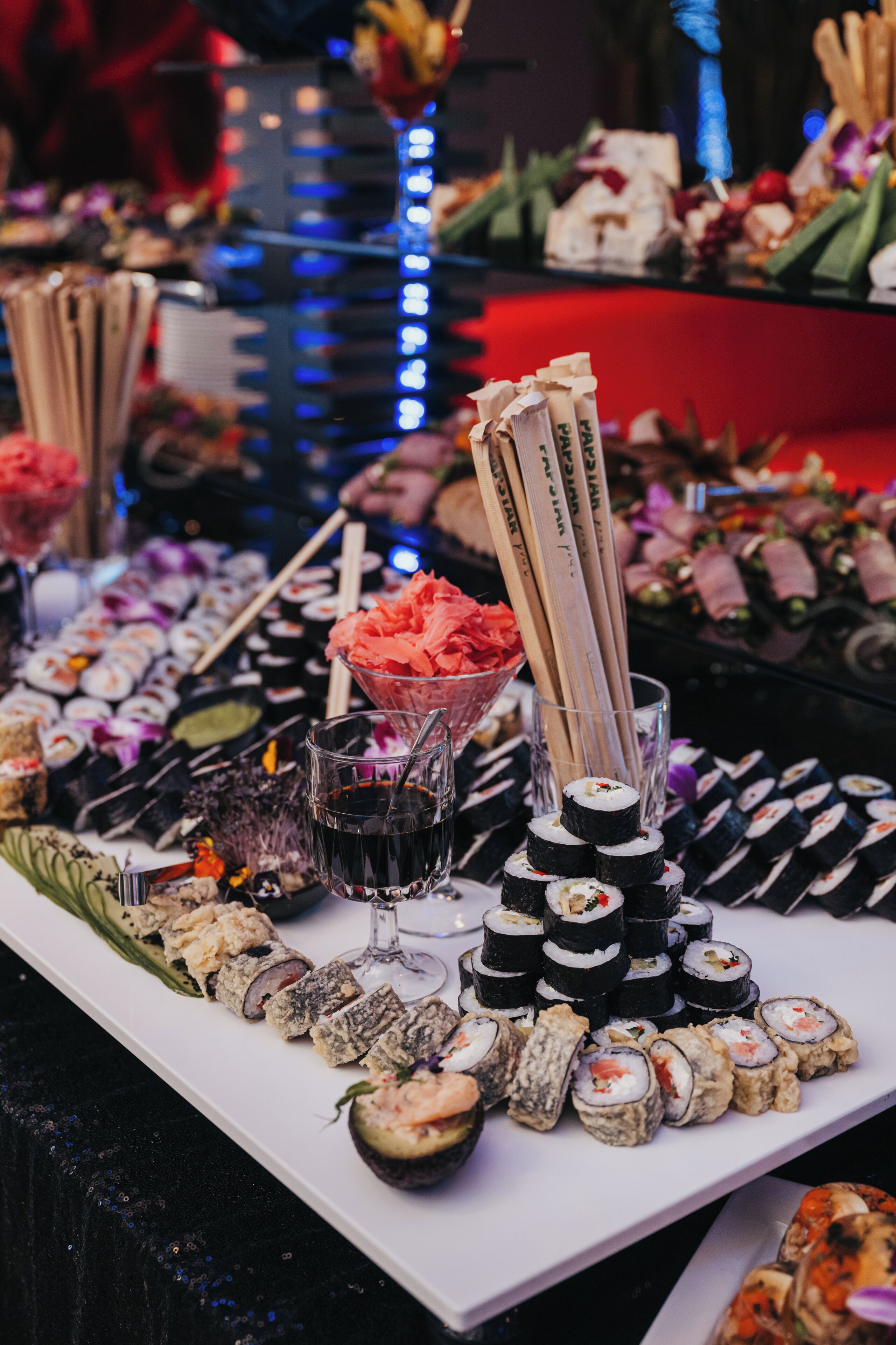 A sushi platter with various types of sushi and a glass of sake.