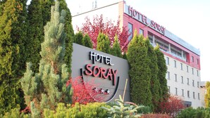 A hotel sign with the name 'Hotel Soray' surrounded by evergreen trees and red foliage. - Hotel Soray (Wieliczka)