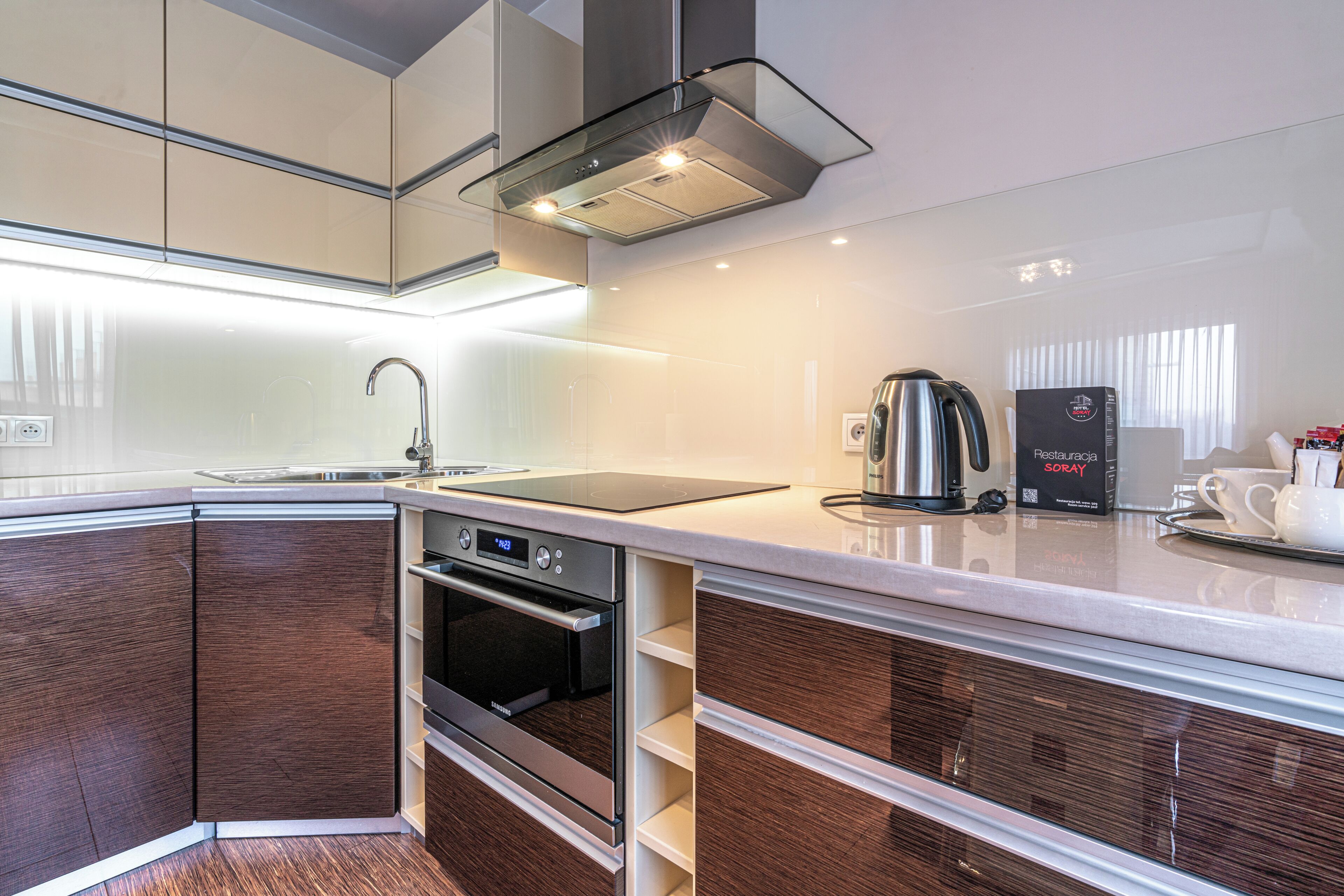 A modern kitchen with a built-in oven, a coffee maker, and a microwave.