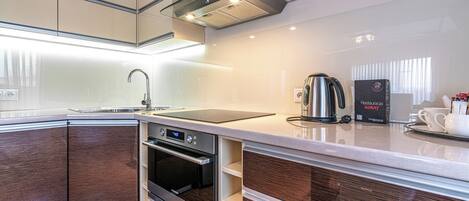 A modern kitchen with a built-in oven, a coffee maker, and a microwave.