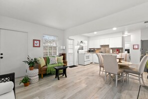 A modern apartment with a living room, dining area, and kitchen. - Bayside Escape | Cozy Hideaway Near Bayshore (Tampa)