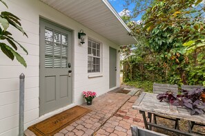 Uma casa com porta da frente, um pequeno alpendre e um tapete de boas-vindas.