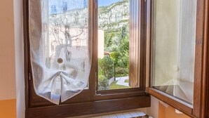 A window with a view of a mountainous landscape and a building. - Tina Home Lake View (Garda)