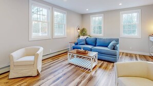 A spacious living room with a blue sofa, white armchairs, and a wooden coffee table. - Enchanting 3BR Farmhouse Retreat  Nature Getaway (Gorham)