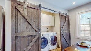 A laundry room with two washing machines, a sink, and cabinets. - Enchanting 3BR Farmhouse Retreat  Nature Getaway (Gorham)
