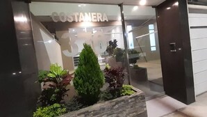 A storefront with the name "COSTANERA" and the number "3516" visible through the glass. - Beautiful apartment with balcony facing the sea (Lima)