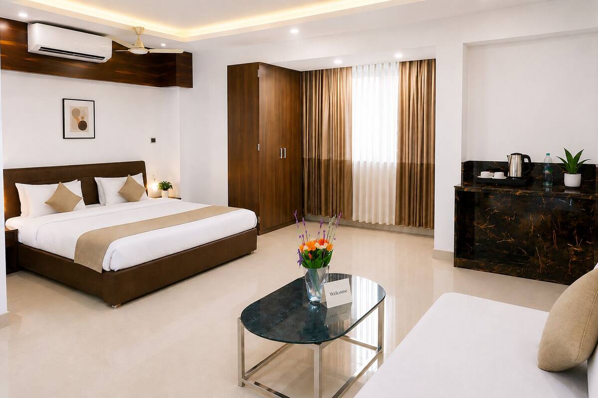 A hotel room with a bed, a desk, a wardrobe, and a reception desk.