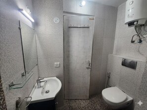 Une salle de bain avec une douche, des toilettes et un lavabo.