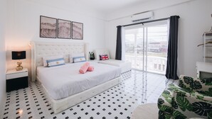 A bedroom with a large bed, a nightstand, a lamp, a window with curtains, and a view of the city. - 2BR with Private Pool and Rooftop Jacuzzi in Huahin Ocean & Mountain View (หัวหิน)