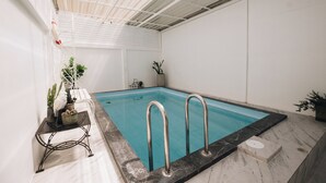 An indoor swimming pool with metal railings, potted plants, and a tiled floor. - 2BR with Private Pool and Rooftop Jacuzzi in Huahin Ocean & Mountain View (หัวหิน)
