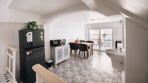 A compact kitchen with a refrigerator, microwave, and dining area. - 2BR with Private Pool and Rooftop Jacuzzi in Huahin Ocean & Mountain View (หัวหิน)