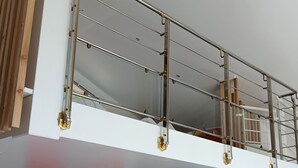Un bâtiment à deux étages, doté d’un balcon à l’étage supérieur, d’une porte en bois et d’un tableau abstrait rouge au rez-de-chaussée.