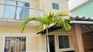A two-story building with a balcony and a small palm tree in front. - Beach house in Arraial do Cabo, Summer Beach condominium. Also through other platforms (Arraial do Cabo)