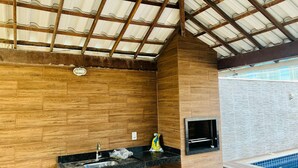 A bathroom with wooden walls, a black countertop sink, and a tiled shower area. - Beach house in Arraial do Cabo, Summer Beach condominium. Also through other platforms (Arraial do Cabo)
