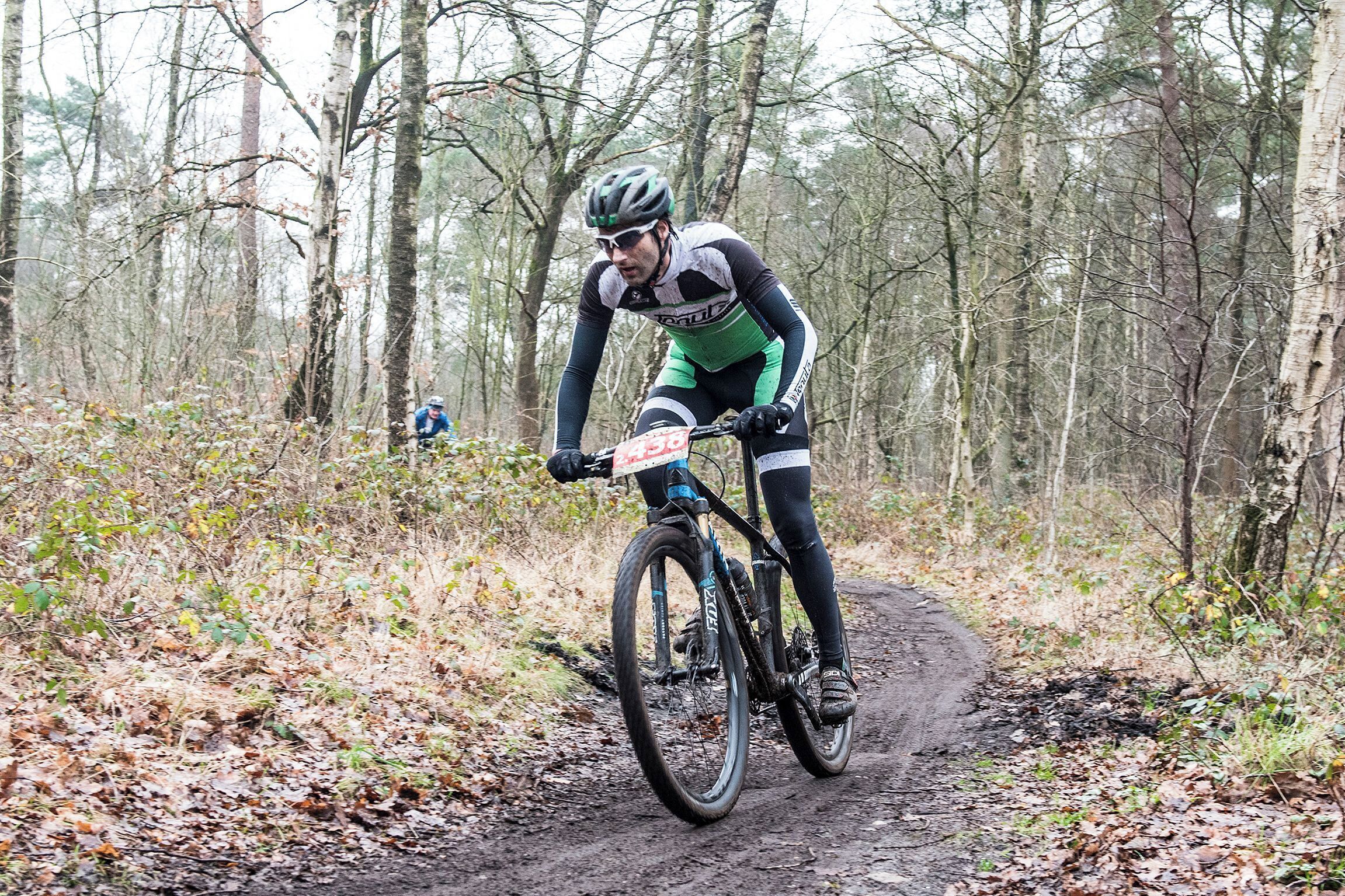 A cyclist on a mountain bike trail surrounded by trees.