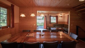 A wooden interior with a large dining table, chairs, a sofa, and a chessboard. - Attractive Swedish group accommodation by the meadow (Soest)